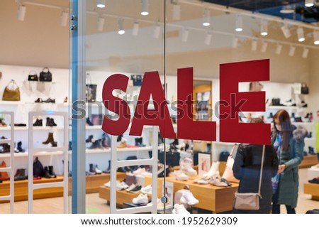 Sale time in footwear store at european shopping center. Christmas promotions in shop. Seasonal sale, holiday discounts in shopping mall.