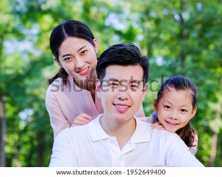 Outdoor portrait of a happy family of three smiling