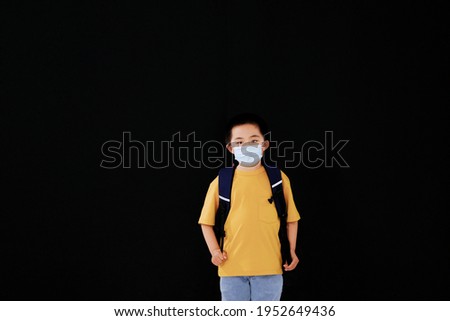 The little boy with mask goes to school standing