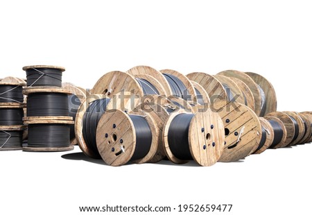 Wooden Coils Of Electric wire Outdoor. High and low voltage cables on white background. Large cable for electrical work. Royalty-Free Stock Photo #1952659477