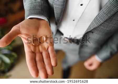 A man in love makes an offer to a woman. Wedding rings in a man's hand.