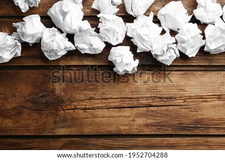 Crumpled sheets of paper on wooden background, flat lay. Space for text