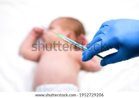 Pediatrician vaccinating newborn baby. Vaccine, Vaccination for infant child Soft focus Syringe in hands of nurse and blurred background of infant  baby on white. Doctor in blue gloves close up. Mpox Royalty-Free Stock Photo #1952729206