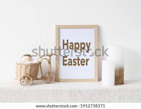 Wooden frame with text "HAPPY EASTER", candles, easter egg on white background. Easter home decor. 