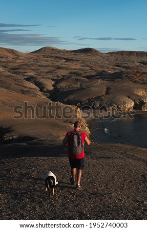 A man walk with a dog downhill at Cabo de la Vela, Guajira, Colombia