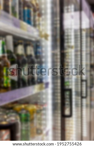Refrigerated glass showcases with alcoholic beverages in the store. Blurred. Vertical.