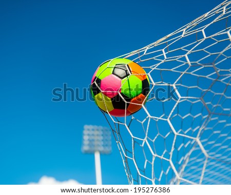 colorful soccer ball in goal net 