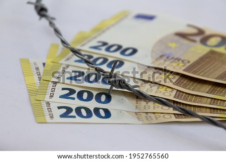 200 euro banknotes fanned with barbed wire and isolated on white