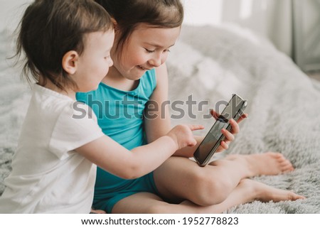 Children watch cartoons on the phone. Early addiction to gadgets. Early development of modern children