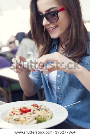 Hipster woman taking a picture of italian meal 