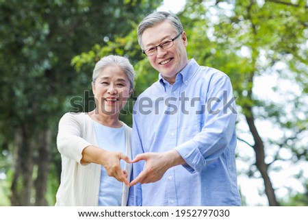 Portrait of happy old couple with Heart gesture