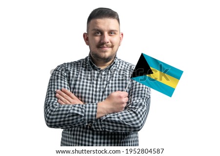 White guy holding a flag of Bahamas smiling confident with crossed arms isolated on a white background.