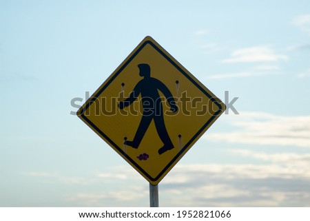 Pedestrian crossing sign with sky in the background