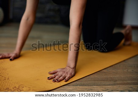 Cutout picture of a woman kneeling on a yoga mat and practicing yoga.
