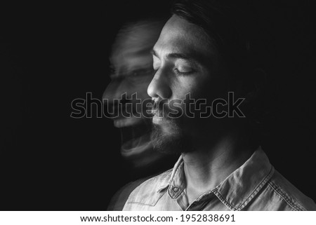 Image of a man meditating with his eyes closed leaving a blurred image, screaming euphoric, uncontrolled. Long exposure photography. Concept of mental effects of pandemic. Copy space Royalty-Free Stock Photo #1952838691
