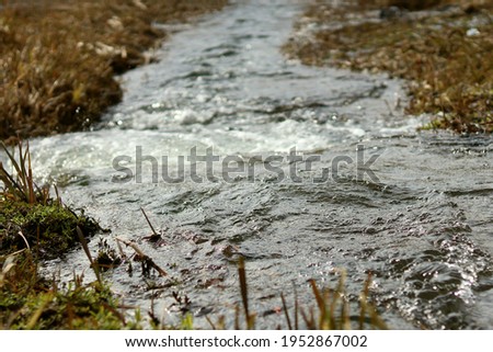 the river flows into another river with a small waterfall