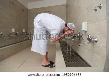 A Muslim takes ablution for prayer. Islamic religious rite Royalty-Free Stock Photo #1952906686
