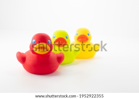 Three different colored bath ducks for baby grooming, isolated on white background.