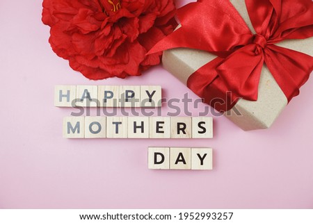 Happy Mothers day alphabet letter with gift box and red flower decoration on pink background