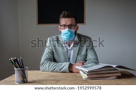 Teacher in classroom wearing a medical mask school reopening	