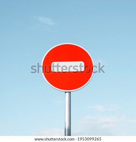 Round road sign No Entry, on a pole against a clear blue sky.