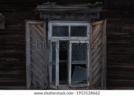 The window of an old wooden house. A window with shutters.