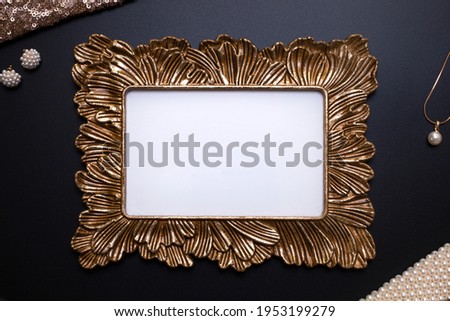 Elegant background, template for text, logo or picture. Golden decorative picture frame and jewellery on the black background. Free space, copy space.