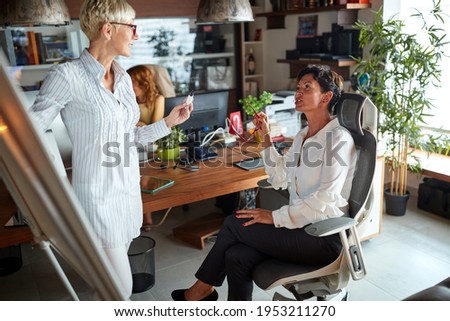 Female colleagues talking about a job in a pleasant atmosphere at their workplace. Business, office, job
