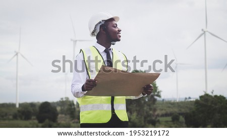 African engineer man working on site wind turbine with light flare on background.Concept of sustainability development by alternative energy