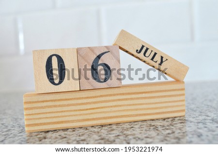 July 6, Cover design with number cube on a white background and granite table.