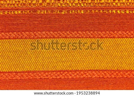 Rustic canvas fabric texture in red, orange and yellow woven color.