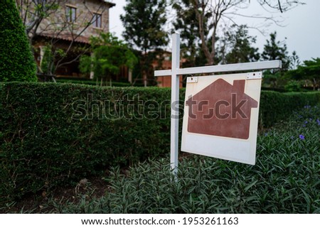 Blank sign of home for sale real estate with beautiful brick house in background