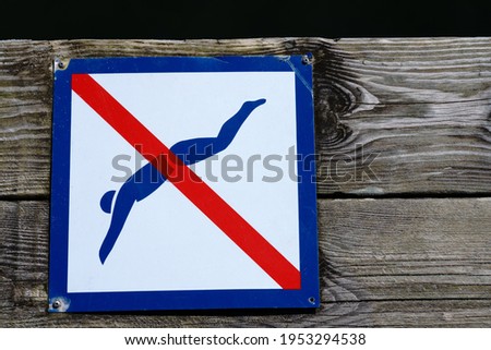 No diving sign on wooden jetty.