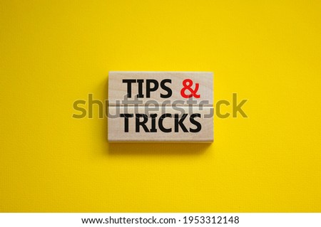 Tips and tricks symbol. Wooden blocks with words 'Tips and tricks'. Beautiful yellow background. Business, tips and tricks concept. Copy space.