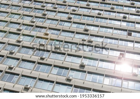 The texture of the facade of a soviet building with a lot of windows and air conditioners