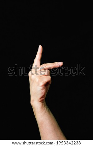 Hand making and showing Letter K International sign language dark background
