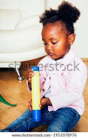 little cute african american girl playing with animal toys at home, pretty adorable princess in interior happy smiling, lifestyle real people concept