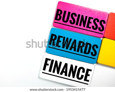 Business and finance concept. Text BUSINESS,REWARDS,FINANCE on colorful wooden board on white background.