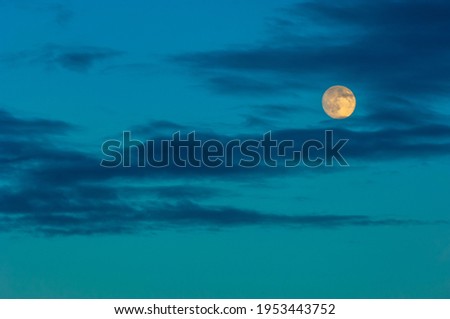 Night photo. The moon in the sky with clouds is colored by the sun. moonlight, moonshine, shine