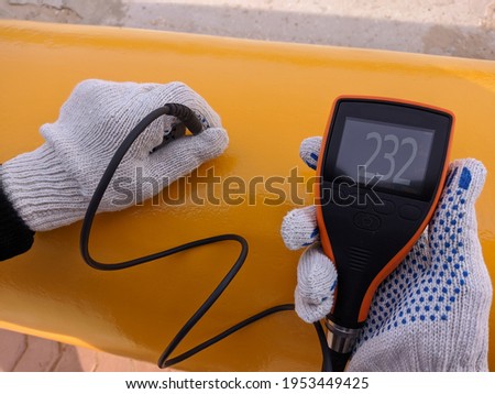 Gas industry. Quality control of the protective coating of the gas pipeline. Measurement of the paint coating thickness. Selective focus. Royalty-Free Stock Photo #1953449425