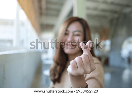 A beautiful young asian woman making and showing mini heart hand sign