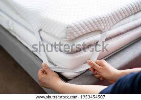 Mattress Topper Being Laid On Top Of The Bed Royalty-Free Stock Photo #1953454507