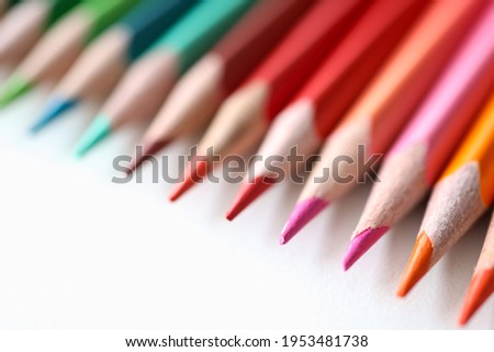 Many multicolored pencils lying on white background closeup