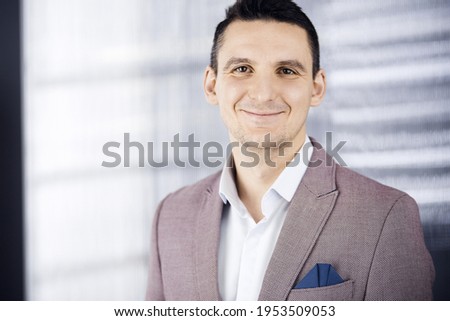 Friendly adult businessman in pink jacket. Business headshot or portrait in office