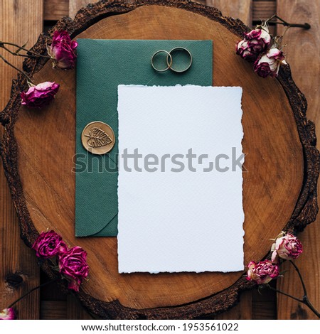 Wedding Flat lay. Wedding invitation set with card mockups for instagram. Wedding set with rings and dark green envelope and an invitation form on a wooden background with bush rose flowers