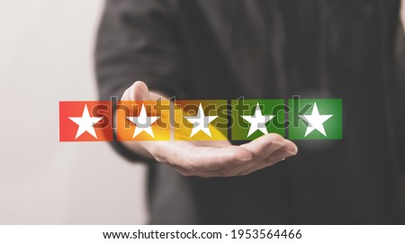 Customer review good rating concept hand holding five star on visual screen and positive customer feedback testimonial.