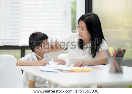 Mother and son doing homework at home, Mother is teaching son to draw pictures, Children homework. Young boy. doing homework on the terrace at home. Happy mood. Back to school concept.