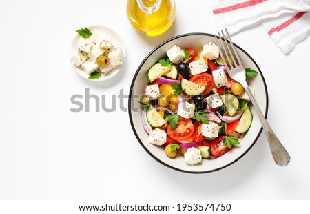 Classic Greek salad with fresh vegetables, feta cheese and olives. Healthy food. White background. Top view	 Royalty-Free Stock Photo #1953574750