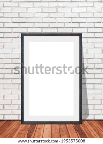 Black blank frame in white brick wall with wooden floor texture interior room background, Mockup template for your content or design.