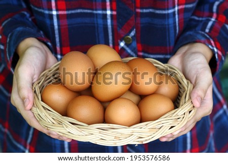 female farmer holds a raw egg in a basket